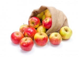 Fresh red apples spreading out from burlap bag
